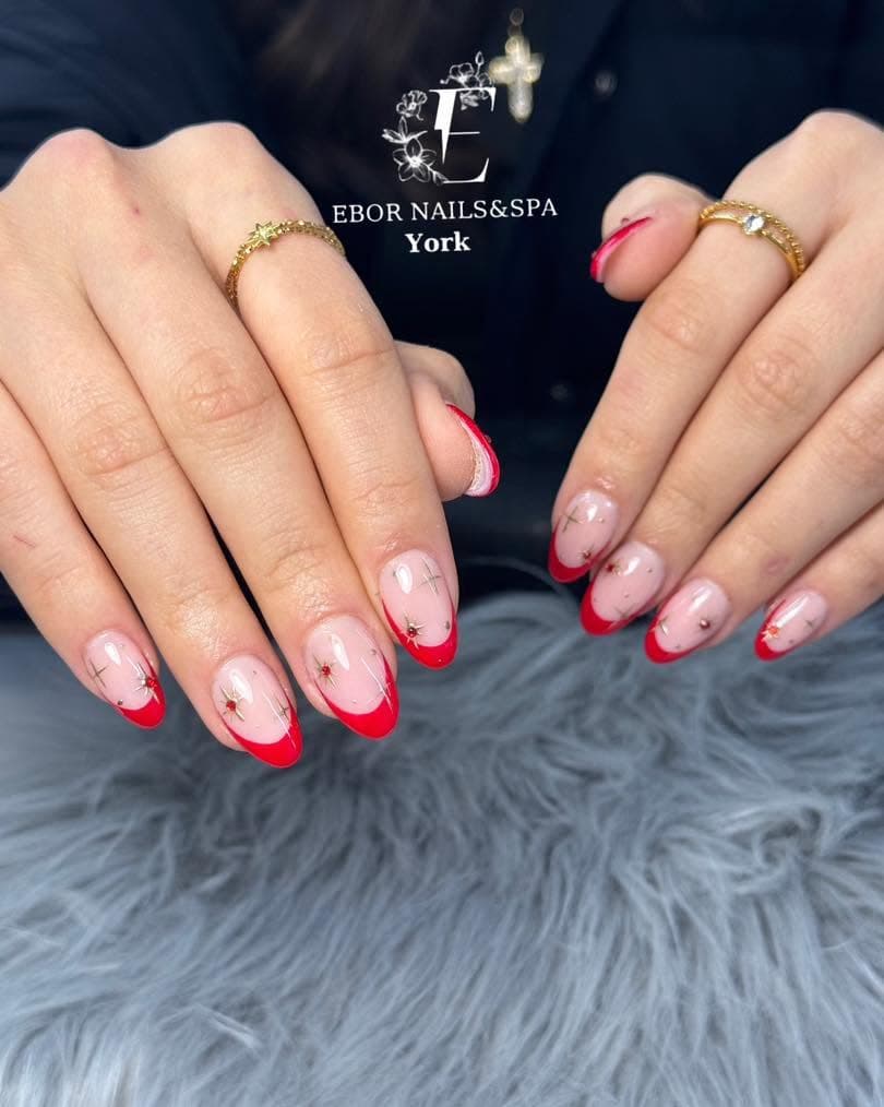 Short almond nails with red French tips and tiny gems